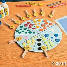 a wooden table topped with lots of crafting supplies next to markers and pencils