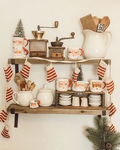 a shelf filled with dishes and cups on top of a wall next to a christmas tree