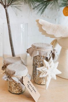 two jars filled with granola next to a christmas tree