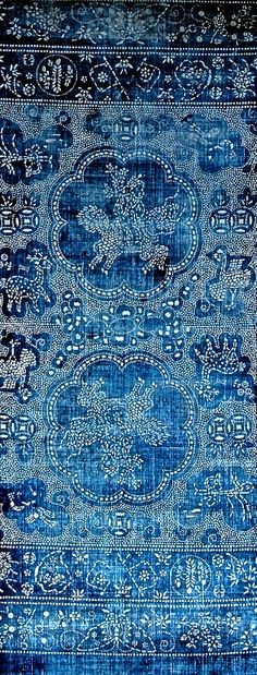 an old blue rug with intricate designs on it