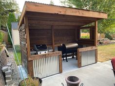 an outdoor bbq with grills and chairs