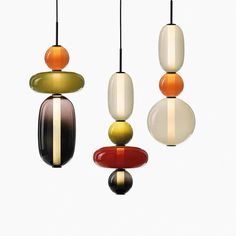 three multicolored glass pendants hanging from strings