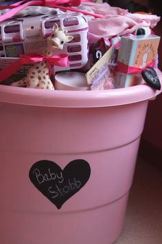 a pink pail filled with lots of baby stuff