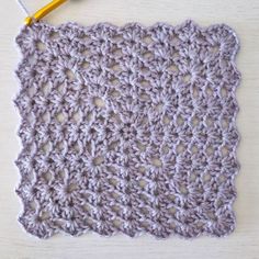 the crochet square is made up of two rows of yarn and has a yellow hook