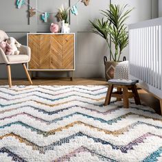 a living room with a rug, chair and potted plant on the sideboard