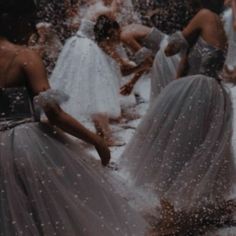 several women in dresses are throwing confetti on each other