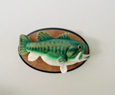 a green fish mounted to the side of a wall