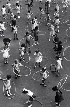 an aerial view of children playing with hula hoop's in a playground area