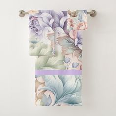 two towels hanging on a towel rack next to each other with flowers painted on them