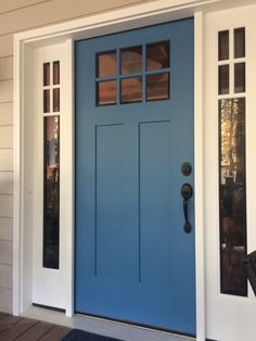 a blue front door with two sidelights and an entry mat on the outside of it