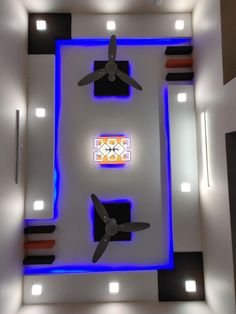 an overhead view of a ceiling fan and some lights in the room with blue lighting