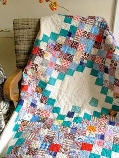 a quilted blanket sitting on top of a wooden chair