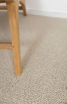 a wooden bench sitting on top of a carpeted floor