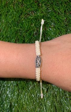 This is our cream colored adjustable bracelet featuring La Virgen De Guadalupe (Blessed Virgin Mary). It is made with Nylon thread from Mexico and is very durable and lightweight.  Model wearing bracelet has wrist size of 6.5 inches. This is adjustable to fit VARIOUS sizes from 6 inches up to 9 inches!  At Cari Boutique, we make our bracelets with the mindset of exceeding our customers expectations! We are a women run business and all our unique trendy bracelets are made by hand, day by day. Interested in our items and looking for more jewelry options? Check out our Instagram for sneak peeks of upcoming jewelry @Cariboutiquenyc Thank you for your interest & if you have any questions please don't hesitate to contact us through our email; @cariboutiquenyc@gmail.com **We ship USPS First Class White Braided Bracelet With Adjustable Cord, White Braided Nylon Cord Bracelet With Adjustable Length, White Braided Bracelets With Adjustable Length, White Braided Bracelet With Adjustable Length, White Braided Bracelets With Sliding Knot Nylon Cord, White Braided Bracelet With Sliding Knot Nylon Cord, Handmade White Nylon Cord Bracelet, White Adjustable Nylon Cord Jewelry, White Braided Bracelet With Sliding Knot