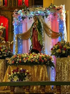 the statue of mary is surrounded by flowers and garlands in front of an altar