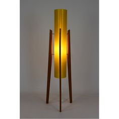 a lamp that is sitting on top of a wooden stand with a yellow light in the middle