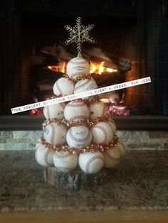 a christmas tree made out of baseballs is sitting in front of a fire place