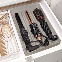 an open drawer with hair brushes and combs