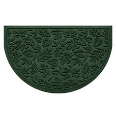 a green door mat with leaves and flowers on the front, in an oval shape