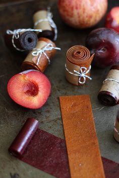 an apple, cinnamon stick, and other items are on a table with some tape