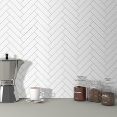 a coffee maker sitting on top of a counter next to two cups and saucers