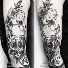 a black and white photo of a rabbit with flowers on its back arm, done by tattoo artist amanda