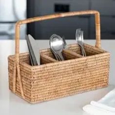 a wicker basket with utensils and spoons in it on a table