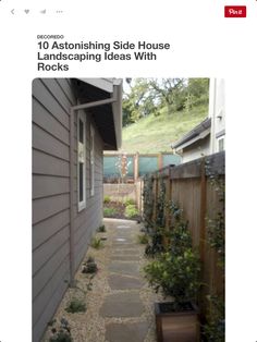 an image of a small backyard with rocks and plants on the side of the house