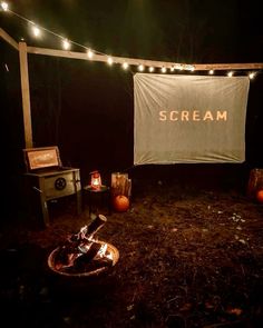 an outdoor area with lights and a sign that says scream on the wall above it