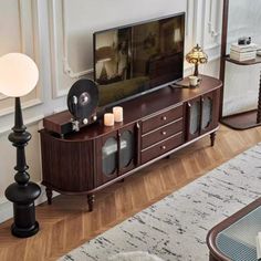 a flat screen tv sitting on top of a wooden entertainment center in a living room