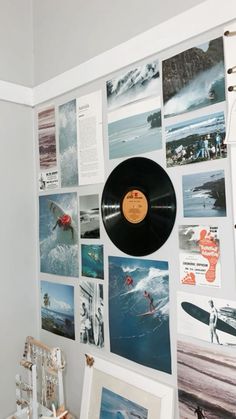 there is a wall with many pictures on it and a record in the corner,