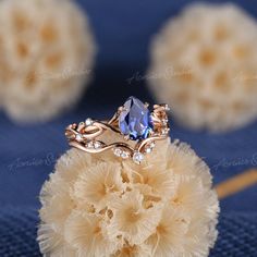 a ring with a blue stone surrounded by crystal stones on top of some corals