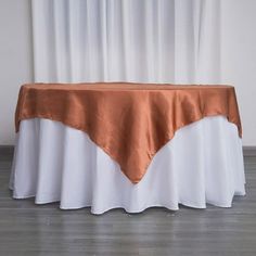 a white and gold table cloth on top of a round table