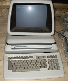 an old computer sitting on top of a wooden table next to a mouse and keyboard