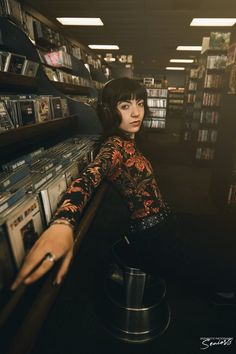 a woman leaning on a shelf in a record store