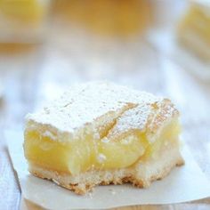 a piece of cake sitting on top of a table next to some lemons in the background