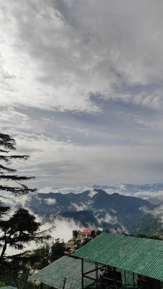 a green roof on top of a building with mountains in the background