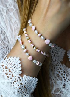 "Gorgeous handmade pink queen conch shell and pearl beaded beach bracelets. Pale pink natural queen conch shell rondelle beads paired with white freshwater pearls and 24k gold plated accent beads on a braided cord with a mother of pearl button closure. Sold individually or by the pair (save when you purchase the pair). Great beach gift for her. Pretty Jasmine Sol gift box included. Beads: 4mm natural pink queen conch shell rondelle, 6mm rondelle pearls in white, 3mm and 4mm 24k gold plated accent beads. Choose Length:  S-6\" M-7\" L-8\" Please measure your wrist to make sure bracelet will fit. Generally you would choose a size that's approximately an inch larger than the circumference of your wrist so it fits comfortably. Photos are close up to show detail. Please refer to measurement info Pink Beaded Bracelet With Pearl Charm As A Gift, Pink Beaded Bracelet With Pearl Charm For Gift, Dainty Pink Jewelry For Beach, Pink Pearl Beaded Bracelets For Jewelry Making, Elegant Pink Beaded Bracelets For Beach, Elegant Pink Bracelets For Beach, Pink Round Bead Bracelets With Pearl Charm, Pink Shell Bracelets As Gift, Pink Pearl Jewelry For The Beach