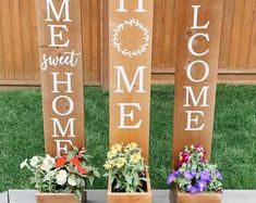 three wooden signs that say welcome, welcome home and welcome home with flowers in them