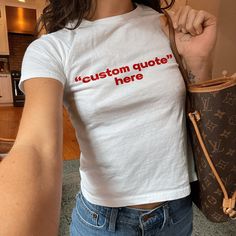 "Personalized Text / Custom Text" Graphic Slogan Printed On Aesthetic Retro Vintage 90s Y2k Baby Tee Shirt with our own unique font. (Model is wearing size XS for reference) 🎁 Our unisex baby tee is a perfect gift for her or him, offering universal comfort, style, and versatility for any occasion. 🧵 Features : ‣ 90s baby tee style (for adults) ‣ 100% cotton ‣ Double-needle stitched neckline ‣ Seamless collar ‣ Classic fit ‣ True to size (see size chart) ‣ Y2K vintage streetwear fashion Baby tees, popular in the '90s, have short sleeves and a slightly cropped body, giving a flattering feminine shape. They originated in the skater/raver scene and were part of the era's child-like fashion trend. 📏 Sizing : Fit's true to size. We recommend sizing down if you prefer a tighter fit. (please no Y2k Fitted Crew Neck Shirt, Fitted Y2k Crew Neck Shirt, Fitted Crew Neck T-shirt With Custom Print, Y2k Fitted Logo Print Tops, Cute Fitted Tops With Logo Print, Y2k Fitted Tops With Logo Print, Y2k Fitted Cotton Shirt, Customizable Unisex White Tops, Y2k Crew Neck Tops With Custom Print