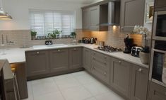 a kitchen with grey cabinets and white counter tops, along with a skylight above the stove