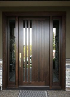 a modern wooden door with glass panels and sidelights on the front of a house