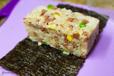 there is a piece of rice cake on the purple plate with some green and yellow sprinkles