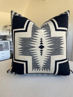 a black and white pillow sitting on top of a bed