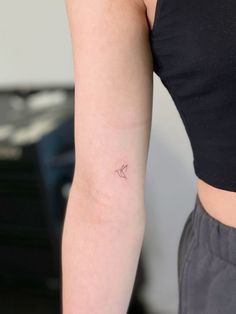 a woman's arm with a small tattoo on the left side of her arm