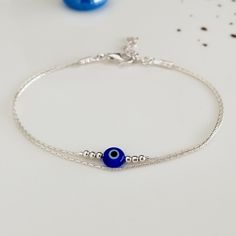 "Minimalist, wearable and delicate sterling 925 silver bracelet of two strands with colored greek evil eye charms. Length: from 5,5\" to 8\" with 1\" (2.5cm) 925 sterling silver extensor chain. Width: 2mm 925 sterling silver beads and 6mm evil eye charms. Chain width: 0,66 mm. Handmade in Spain. Ideal for a gift to silver jewelry lovers. All our products are presented in an organza bag. ♡ Made with love in Valencia ♡ ----------------------------- Discover the NICTE collection here: https://www.etsy.com/shop/NicteShop ♡ Gemstone bracelets > https://www.etsy.com/es/shop/NicteShop?section_id=32205467 * Moonstone jewelry > https://www.etsy.com/es/shop/NicteShop?section_id=32321209 ♡ Gold bracelets > https://www.etsy.com/es/shop/NicteShop?section_id=27642168 * Silver bracelets > https://www.ets Silver Bracelets Evil Eye, Evil Eye Jewelry Bracelet, Evil Eye Bracelet Silver, Evil Eye Bracelet Gold, Silver Evil Eye Bracelet, Greek Evil Eye, Lucky Bracelet, Silver Eye, Protection Amulet