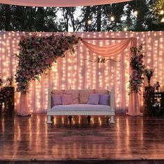 a couch sitting on top of a wooden floor next to a wall covered in lights