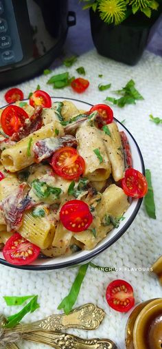 a plate full of pasta with tomatoes and parsley