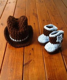 two crocheted baby booties are sitting on a wooden floor