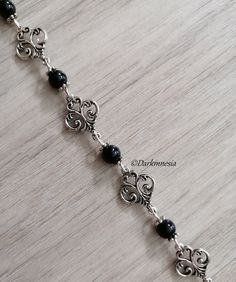 Bracelet with charms and black onyx beads. Black onyx is a stone of protection, it protects from the evil eye, it repels the presence of spirits who would try to influence you, it is very useful for mediums. It promotes a sense of responsibility and helps to maintain self-control by being more composed. Dimensions: 19 centimeters long and 1.3 centimeters wide If you want, I can add an extension chain. Materials used: zinc alloy and onyx (each natural stone being unique, they cannot be identical to the photography) This jewel will be delivered to you in a small organza pouch and sent by registered letter. To keep your jewelry in perfect condition, store them away from humidity and sunlight and avoid contact with water and perfume. Join me on: Instagram: https://www.instagram.com/darkmnesia Handmade Adjustable Gothic Bracelets, Handmade Adjustable Gothic Bracelet, Handmade Gothic Metal Bracelets, Elegant Black Rosary Bracelet, Nickel Free Black Metal Charm Bracelet, Handmade Onyx Black Bracelets, Nickel-free Black Charm Bracelet As Gift, Handmade Black Onyx Bracelets, Adjustable Nickel-free Black Charm Bracelet